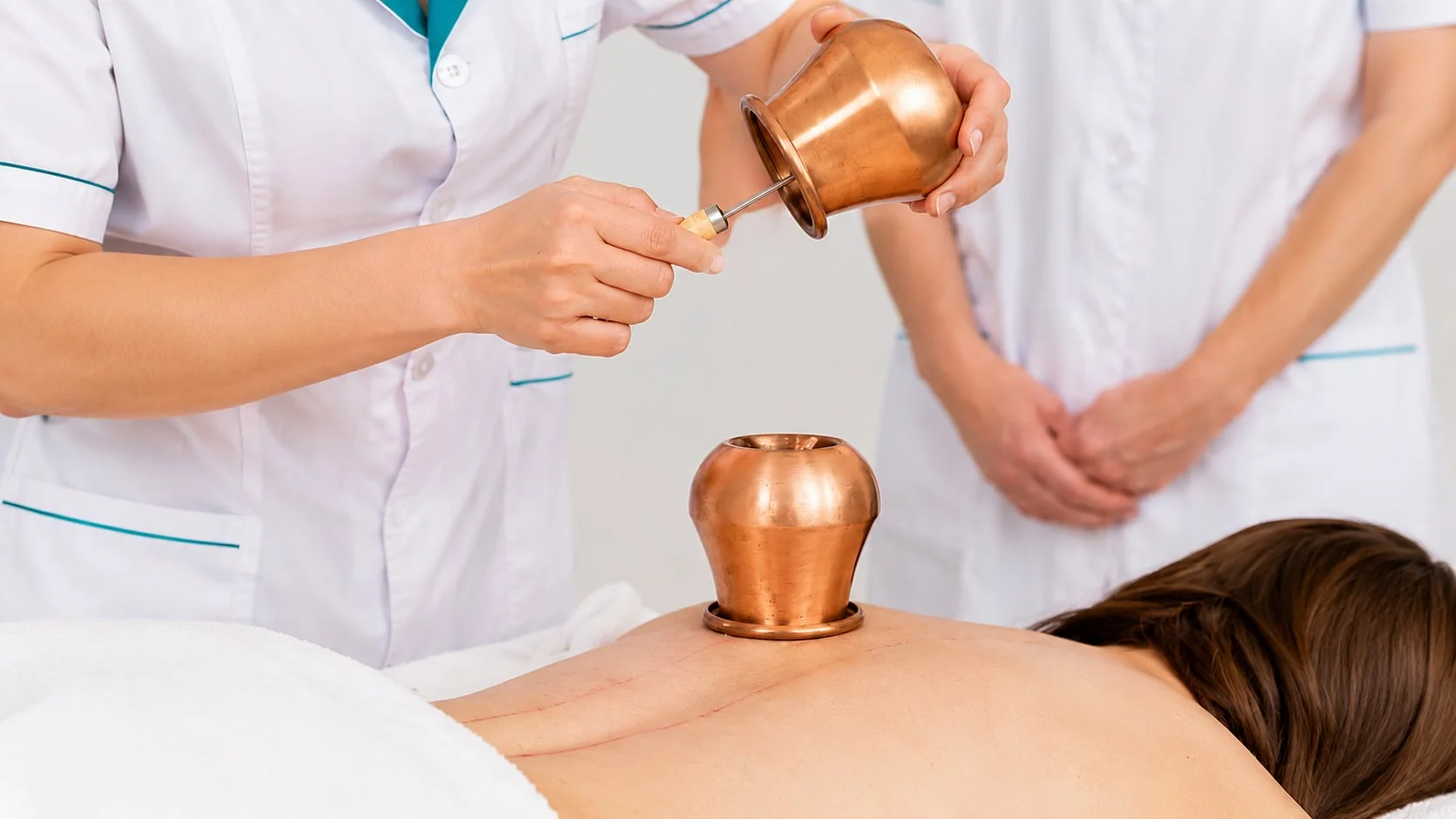 Thermal therapy in the copyrighted programme: moxa heating and copper cups during a Chinese massage session
